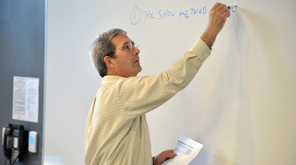 Fred Kaefer writing on a whiteboard